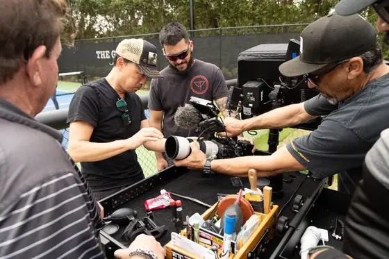 Crew preparing a cinema camera at the equipment cart