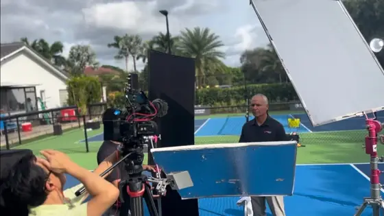 Lit interview setup with bounce and flag on a hard court